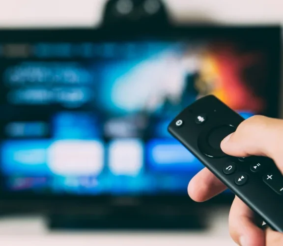 Nowoczesna przystawka typu stick podpięta do portu HDMI w starszym telewizorze LCD.